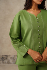 Close-up of contrast stitch line detailing on green linen shirt
