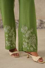 Detail of embroidered floral pattern on green linen pants