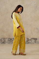 side view Woman wearing yellow Aari embroidered farshi salwar set for haldi with ombre dupatta