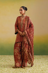 Full view of Woman wearing rust printed farshi salwar set with embroidered neckline and dupatta,paisley print, chevron print, embroidery neckline, green contrast